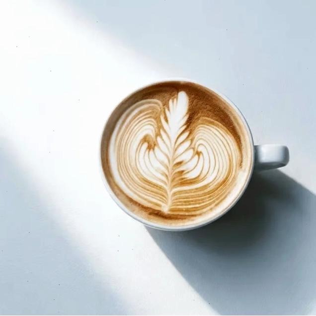 Ly latte với hình rosetta lá dương xỉ trên lớp microfoam trắng, chụp từ trên xuống